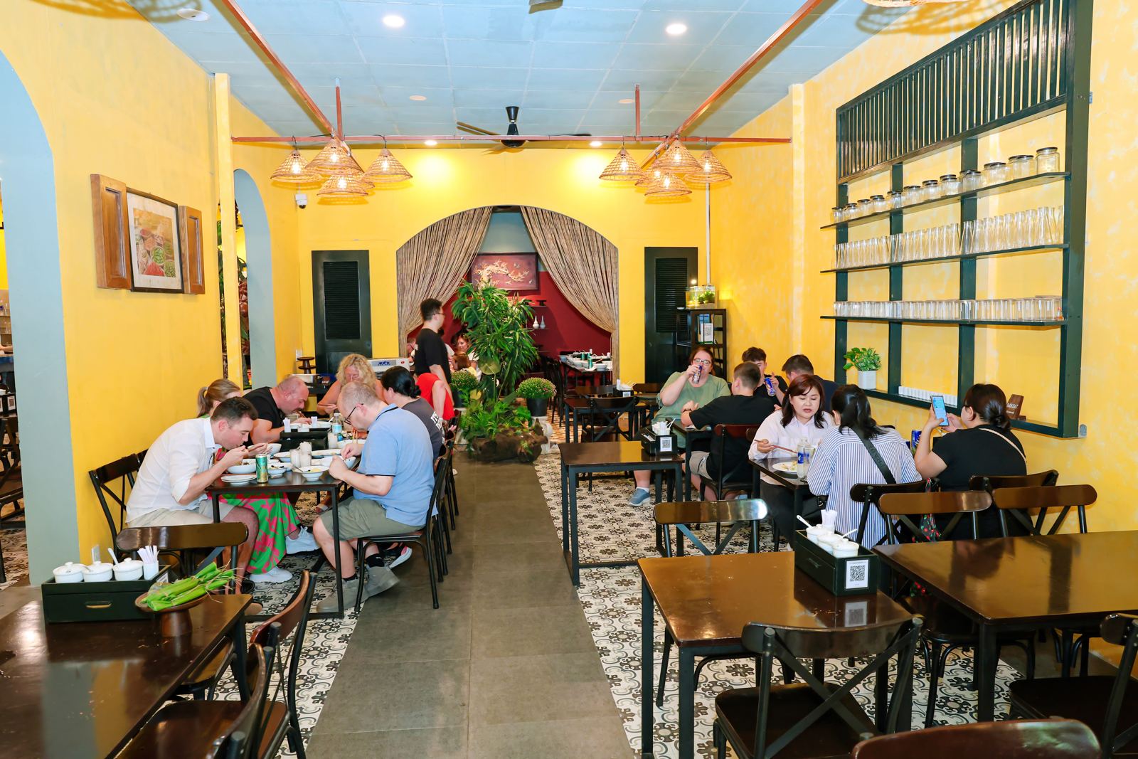 Không gian Bún Bò Gánh 114 Nguyễn Du: tường vàng, đèn mây, thực khách đang dùng bữa